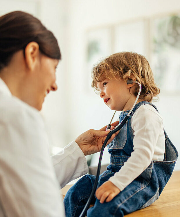 Doctor jokes with little girl during medical treatment